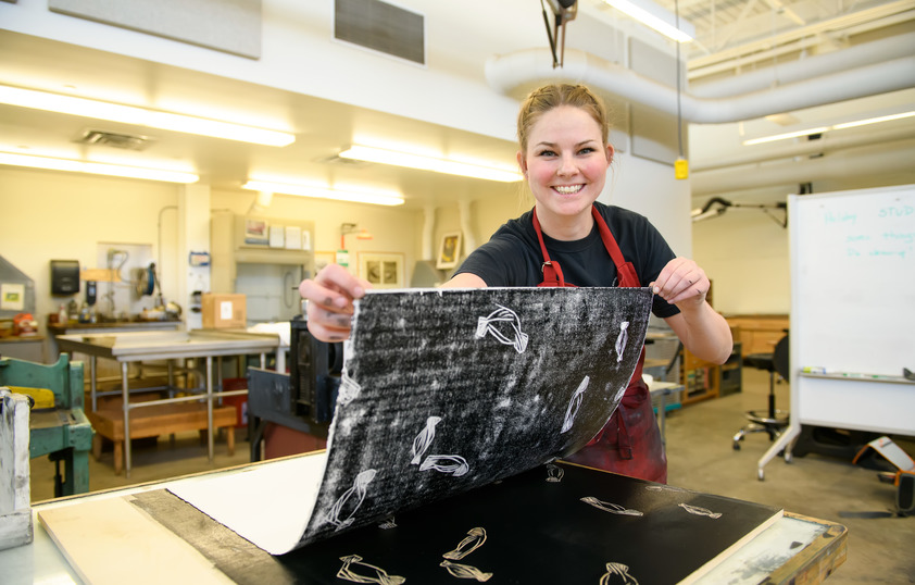 Student in the printmaking studio smiling for a picture