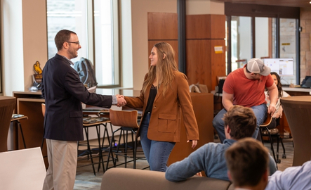 Professor and student shake hands