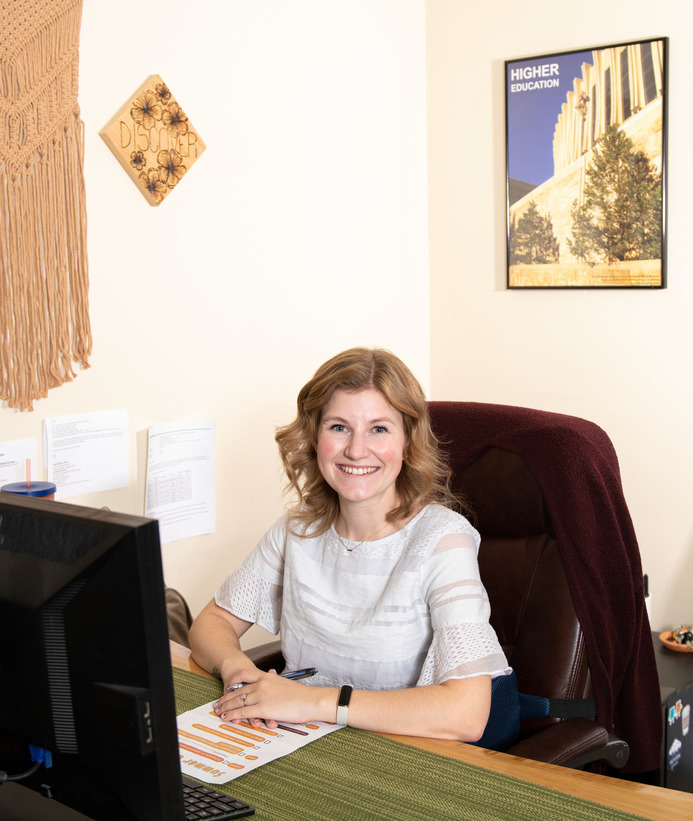 UW staff member sitting at desk and smiling for a picture