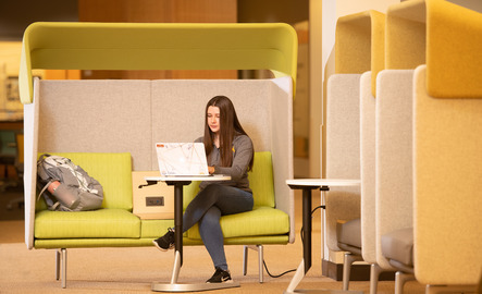 Student writing in a study area