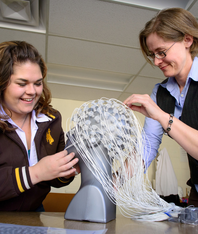 Psychology student and professor working with brain model