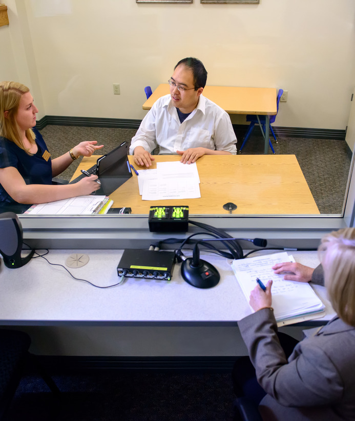Student watches two people in a clinical observation setting
