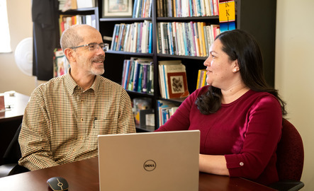 Student and professor sit at the computer