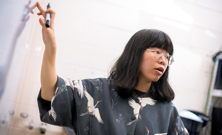 Grad student points at white board