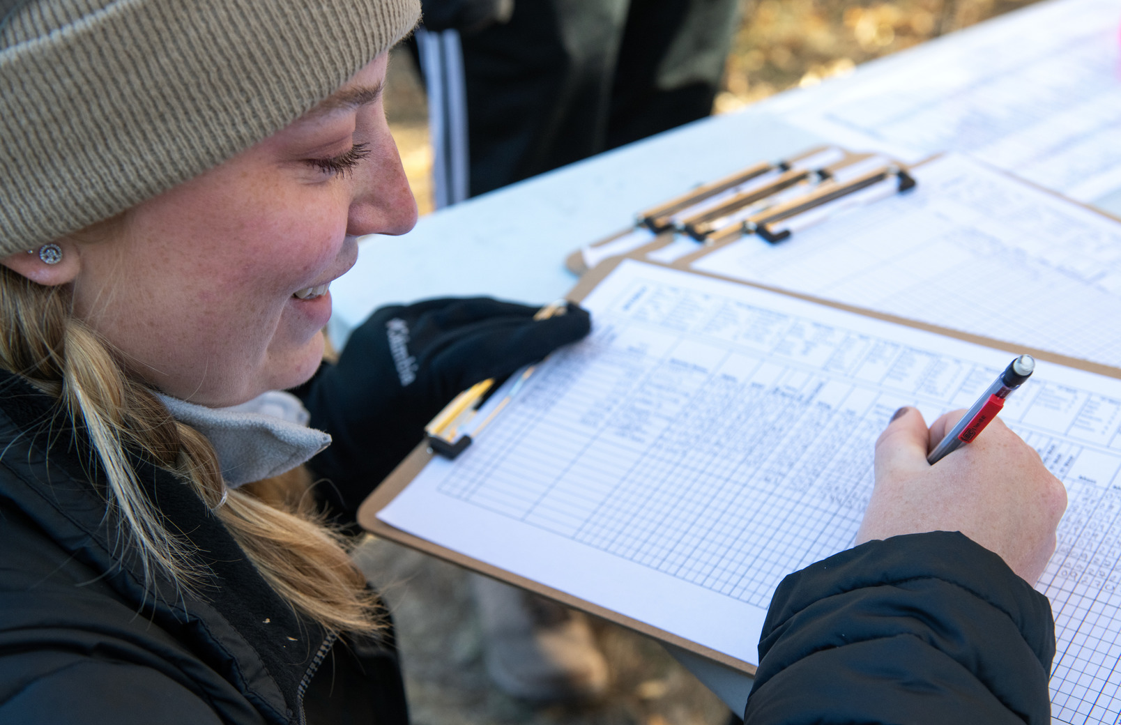 A student writes down numbers on a piece of paper out in the field