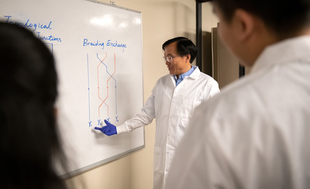Professor points at a white board