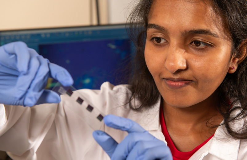 Student holds up slide with quantum materials