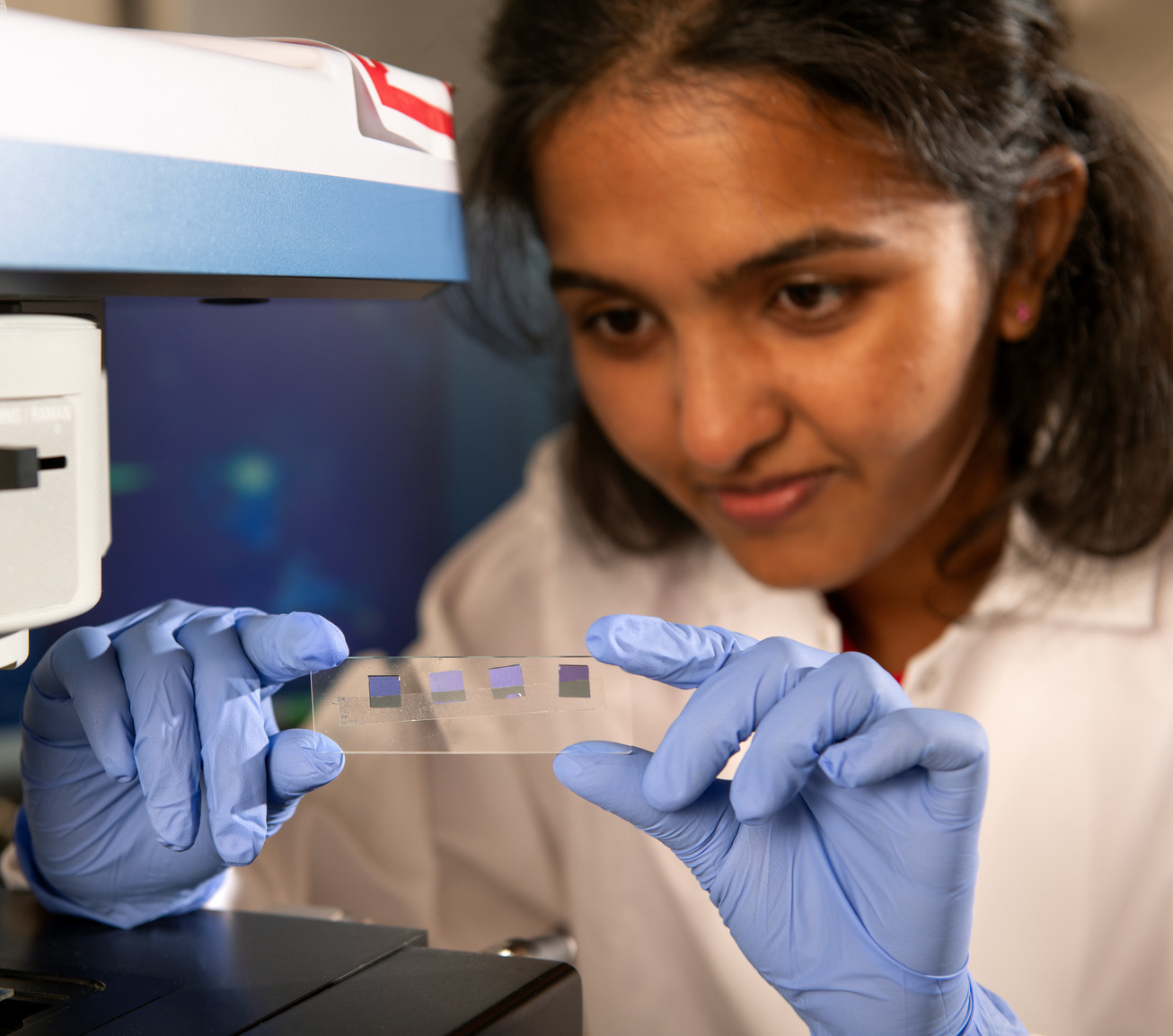 Student in lab examining a petri dish