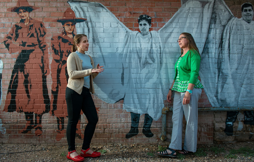 Two people standing in front of Matthew's Angels mural