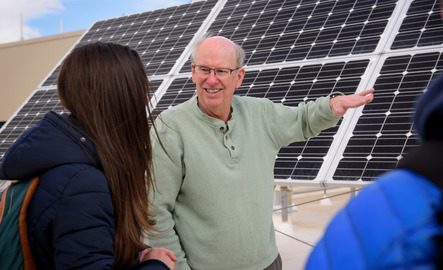 A professor points at a solar panel during class
