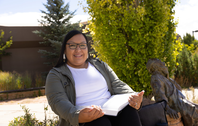 Alum sitting with book open 