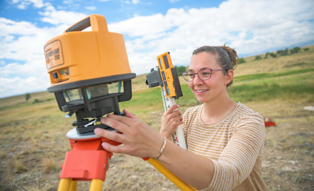 Student in the field using ecology equipment