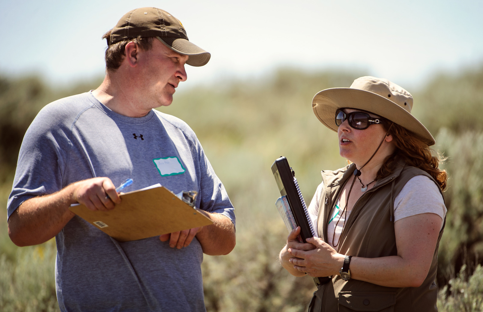 A student and faculty member discuss a project in the field.