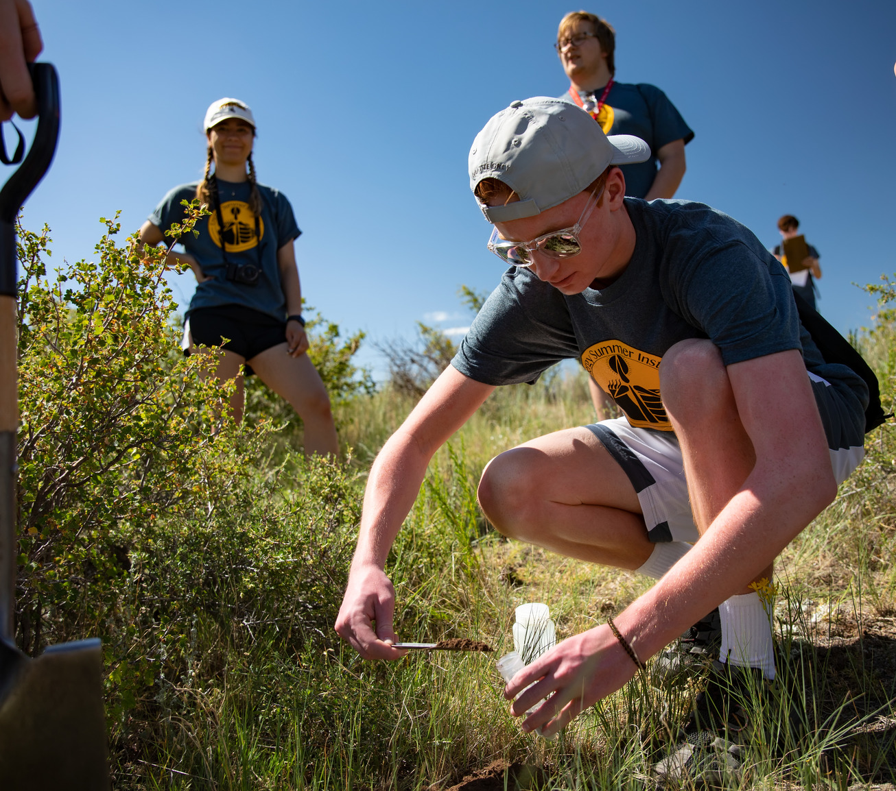 A student works in the soil on a field project.