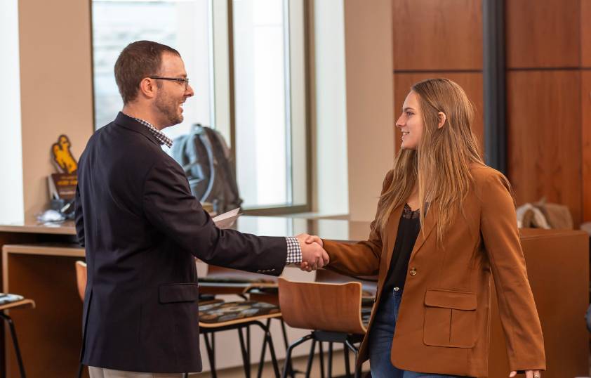 Professor and student shaking hands
