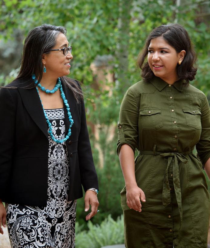 Two graduate students walk on campus