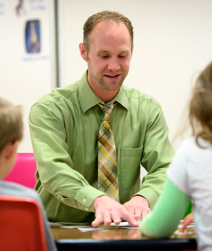 A teacher teaches a group of students at a table