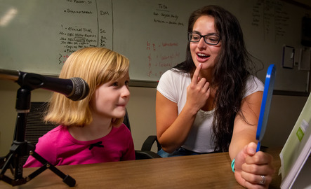 A graduate student works with a child in the Speech and Hearing Clinic