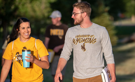 Two students walk on campus together