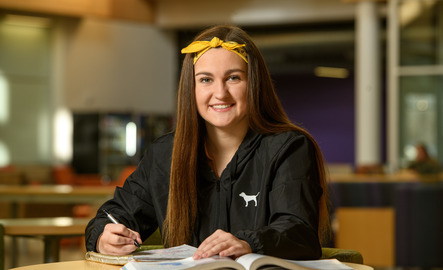 Student smiling and working on coursework