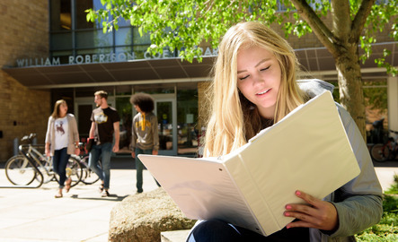 Student looking over course material outside of a UW library