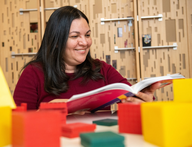 A teacher reads a book