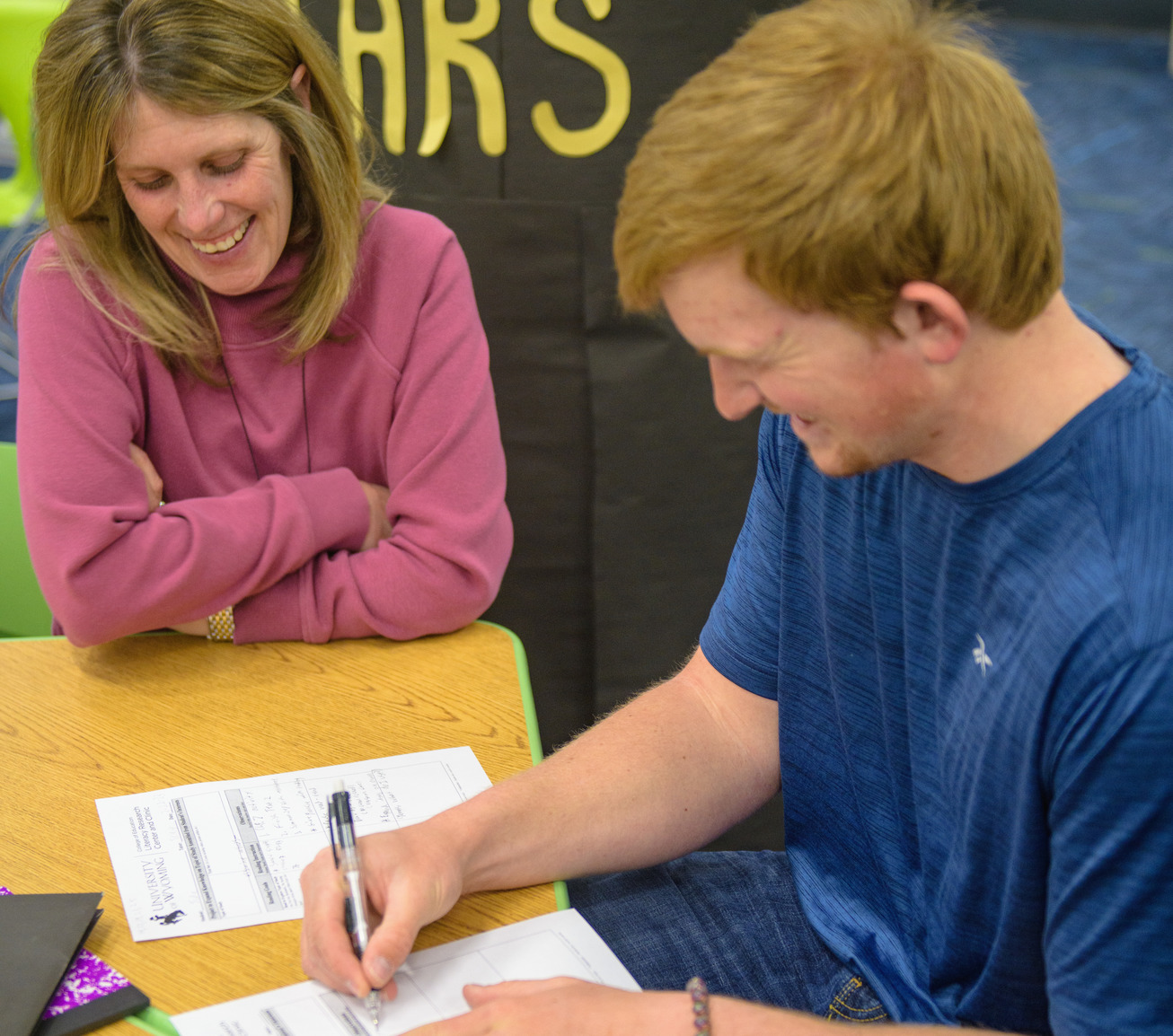 Child writing "W's" on a worksheet