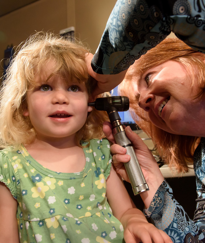 Audiologist looks at a child's ear