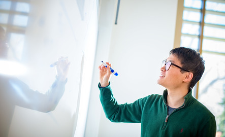 Statistics teaching assistant working on white board