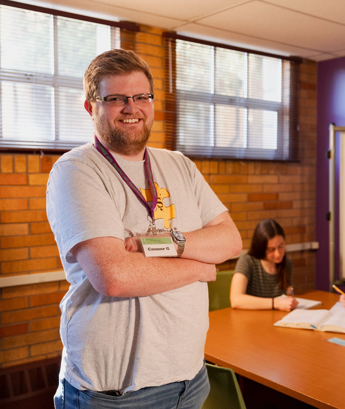 A student smiles for a photo in a tutoring room