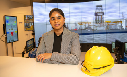A student smiles for a photo in the drilling simulator