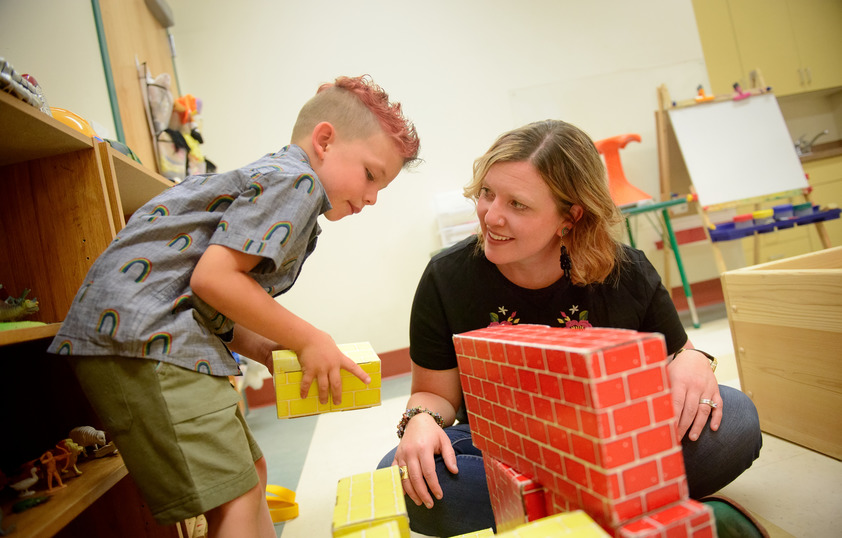 Teacher building blocks with student