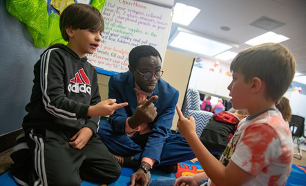 Teacher talks to two students