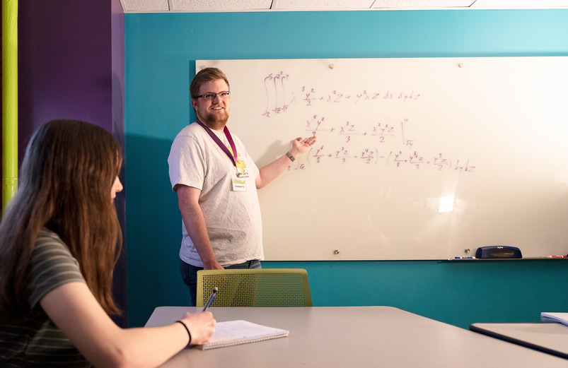 Math teacher points at the board