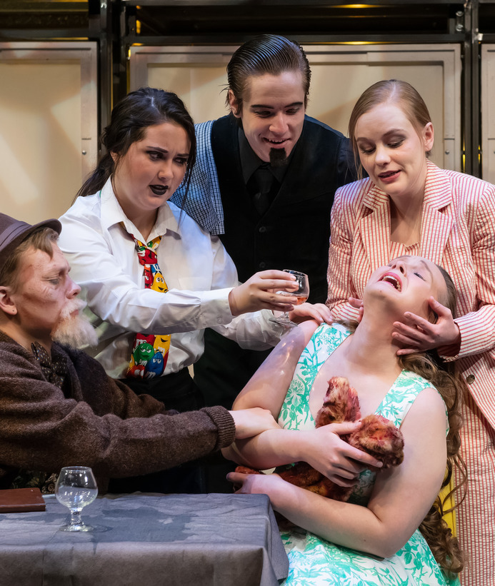 A group of students perform a scene on stage