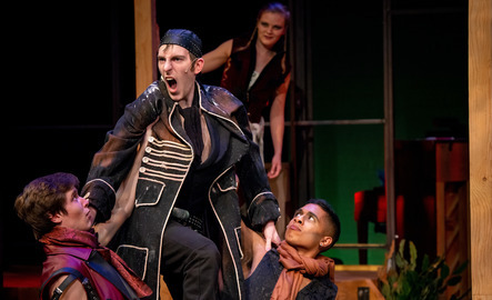 A group of students perform a scene on stage