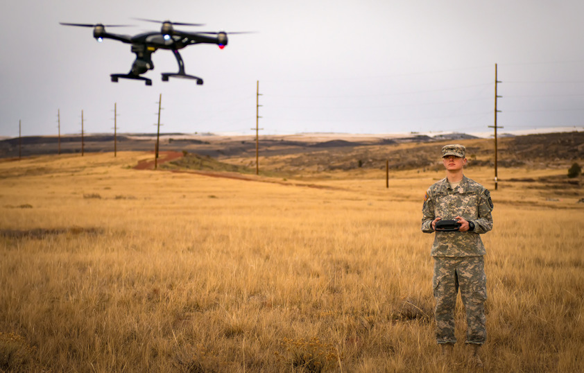 An ROTC student flied a drone in the field.