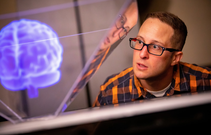 Associate Professor Brandon Gellis of the Art and Art History Program looks at a digitally projected image of a brain