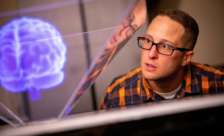 UW visual communication design professor looks at an image of the brain