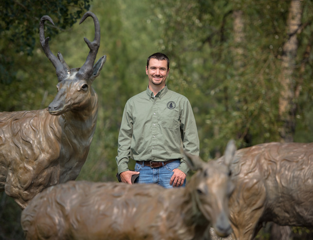 Alum posing with pronghorn statue