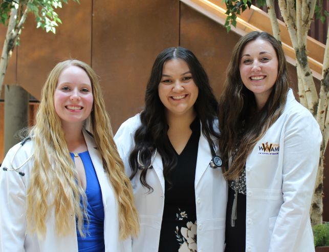 Three WWAMI students smile for a photo together