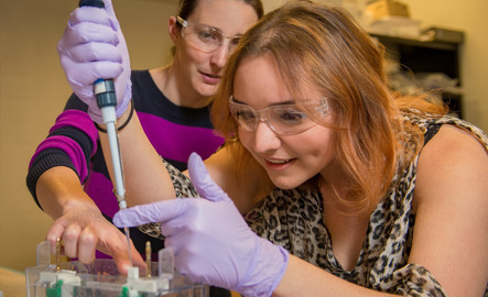 Student holds a pipette in the lab