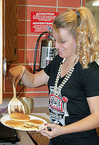 Student serving pancakes