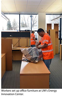 Workers set up office furniture at UW’s Energy Innovation Center.