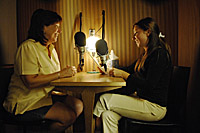 Two women speaking into microphones