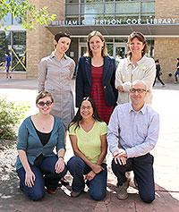 six people posed in front of library
