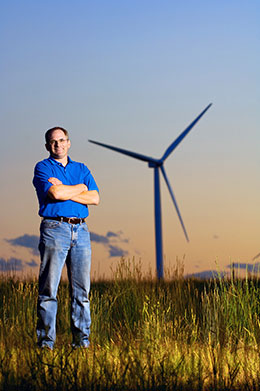 Man standing in front of wind turbine