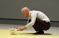 man crouching on floor working on art installation