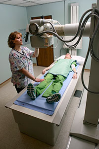 woman using x-ray machine on another woman