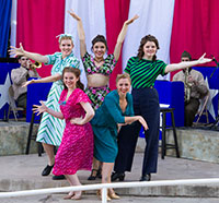 group of women wearing 1940s clothing on a stage